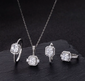 Macro view of square cut diamond jewelry set with halo setting on stone background