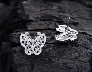 Détails macro de boucles d'oreilles papillon avec diamants baguette et ronds pavés