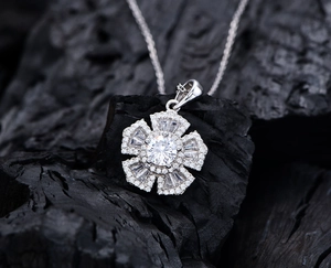Macro shot of silver flower pendant set with sparkling round and trapezoid cut zircons
