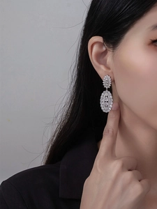 Vue macro des boucles d'oreilles en argent avec zircons blancs et pendentif ovale