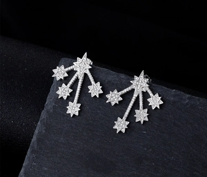 Macro view of S925 silver star stud earrings with cubic zirconia on black rock