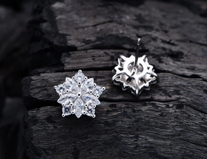 Dettaglio macro di orecchini a stella in argento S925 con zirconi 5A scintillanti