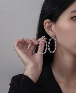 Detailed close-up of large S925 silver oval hollow earrings with sparkling micro-pave zircons
