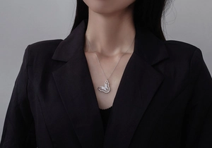 Detail of silver butterfly pendant necklace with zircon inlay on a model neck