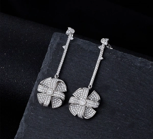 Macro detail of silver windmill earrings with shimmering pavé micro-inlay stones