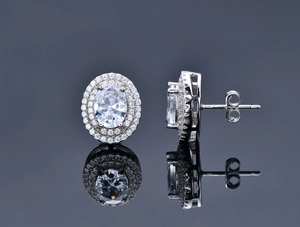 Macro detail of oval cut silver studs with double halo pavé cubic zirconia stones
