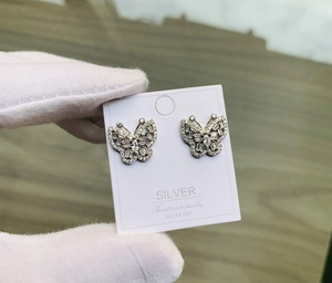 Détail macro de boucles d'oreilles papillon en argent S925 avec zircons micro-pavés