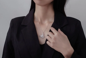 Detail of S925 sterling silver butterfly pendant necklace worn on a black suit blazer