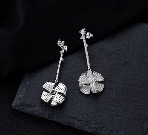 Macro view showing S925 hallmark on silver windmill earrings with zircon pavé details