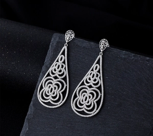 Detailed close-up of water drop earrings with micro-pave crystals and floral patterns