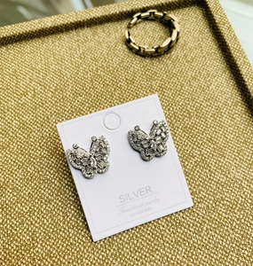 Détail macro de boucles d'oreilles papillon en argent S925 avec zircons sertis