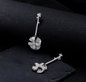 Macro shot of silver windmill drop earrings with micro-pave cubic zirconia crystals