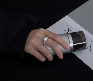 Detail of 925 silver ring with princess cut main stone and marquis accents on finger