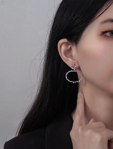Détail de boucles d'oreilles en argent S925 avec zircons portées par un mannequin