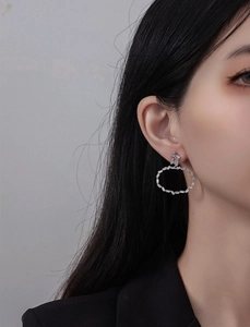 Gros plan de boucles d'oreilles en argent S925 et zircon portées par un mannequin