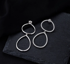 Vue détaillée des boucles d'oreilles argentées avec poinçon S925 et zircons