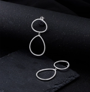 Détail macro de boucles d'oreilles géométriques en argent 925 avec zircons scintillants