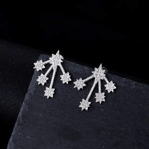 S925 silver shooting star stud earrings with white stones on dark stone background