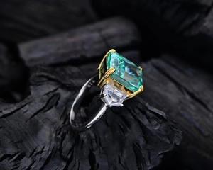 Macro detail of 13ct emerald cut green stone ring with S925 silver hallmark on band