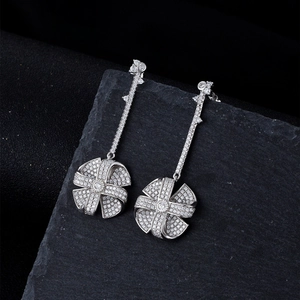 Sparkling silver windmill drop earrings with full cubic zirconia stones on dark stone background