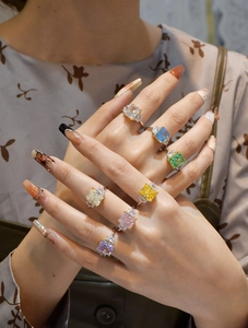 Set mit sieben smaragdgeschliffenen Edelsteinringen in verschiedenen Farben am Finger