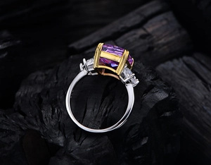 Macro view of 13ct purple cushion cut stone in 925 silver setting on black charcoal