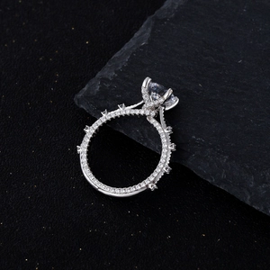 7mm brilliant cut round moissanite silver ring with pavé diamonds on dark stone