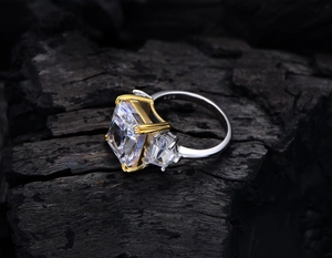Macro detail of 925 silver hallmark on a golden three-stone radiant cut ring