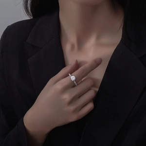 7mm round cut solitaire ring in 925 sterling silver with side stones on a model's hand