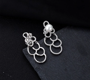 Détail macro de boucles d'oreilles nuages en argent S925 avec grandes perles blanches et zircons