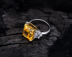 Macro view of 13ct yellow ice-cut carbon diamond ring with 925 silver band on wood