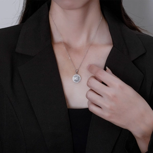 Sparkling S925 sterling silver sunburst pendant necklace worn on a black blazer