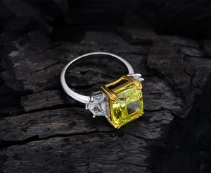 Macro shot of a 13ct emerald-cut yellow carbon diamond ring on dark wood background