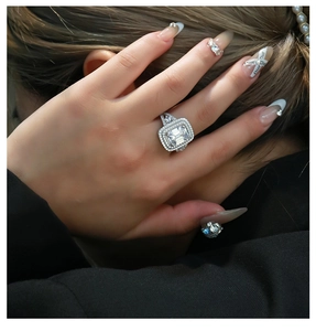 Close-up of radiant emerald cut ring with halo setting on a model's hand