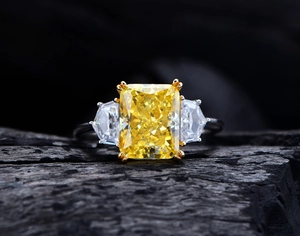 Makroaufnahme von 8x10 gelbem Karbondiamant-Ring mit Eisschliff auf Kohlehintergrund