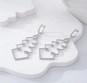 Macro detail of S925 sterling silver Christmas tree drop earrings with pave zircons