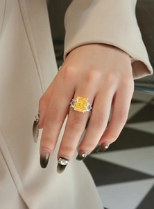 Macro shot of 13ct yellow radiant cut diamond ring with side stones on model hand