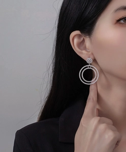 Close-up of double circular silver earrings set with sparkling micro-pave zircons