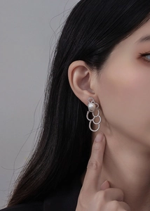 Gros plan de boucles d'oreilles nuage en argent et perles avec zircons sur un mannequin