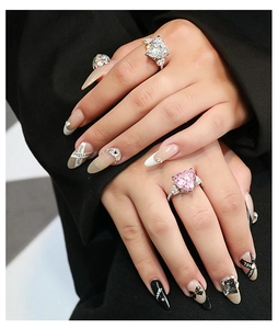 Macro view of a large heart-shaped pink and white crystal ring with pavé stones