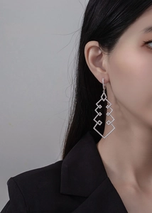 Close-up of geometric S925 silver Christmas tree earrings with pavé-set zircons on a model