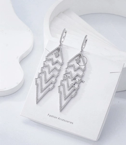 Macro detail of S925 sterling silver stamp and micro-pave zircon tassel earrings