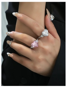 Macro close-up of heart-cut pink and white high carbon diamond rings on hand