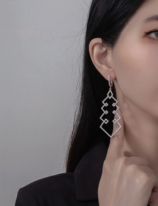Detailed view of long geometric S925 silver earrings with shimmering zircon pavé stones