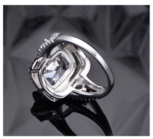 Detailed close-up of emerald-cut high carbon diamond ring on silver band with pavé stones