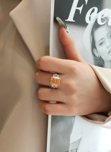Detail of a large champagne rectangle carbon diamond ring with silver band and side stones