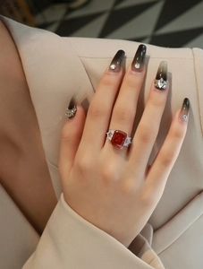 Close-up of a 13ct red cushion cut diamond ring with trapezoid side stones on hand