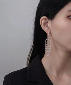 Close-up of geometric V-shaped long tassel earrings with sparkling white cubic zirconia