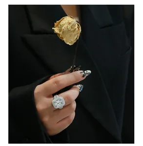 Detailed close-up of emerald-cut gemstone ring with sparkling halo on model's hand