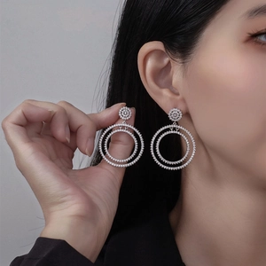 Silver S925 double hoop earrings with pavé micro-set cubic zirconia on female model